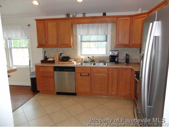 1013 Myra Road Raeford, NC 28376 - Photo 14 of 25 a kitchen with stainless steel appliances granite countertop a sink stove and refrigerator