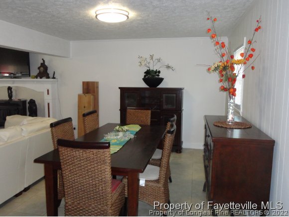 1013 Myra Road Raeford, NC 28376 - Photo 16 of 25 a dining room with furniture a potted plant and a fireplace