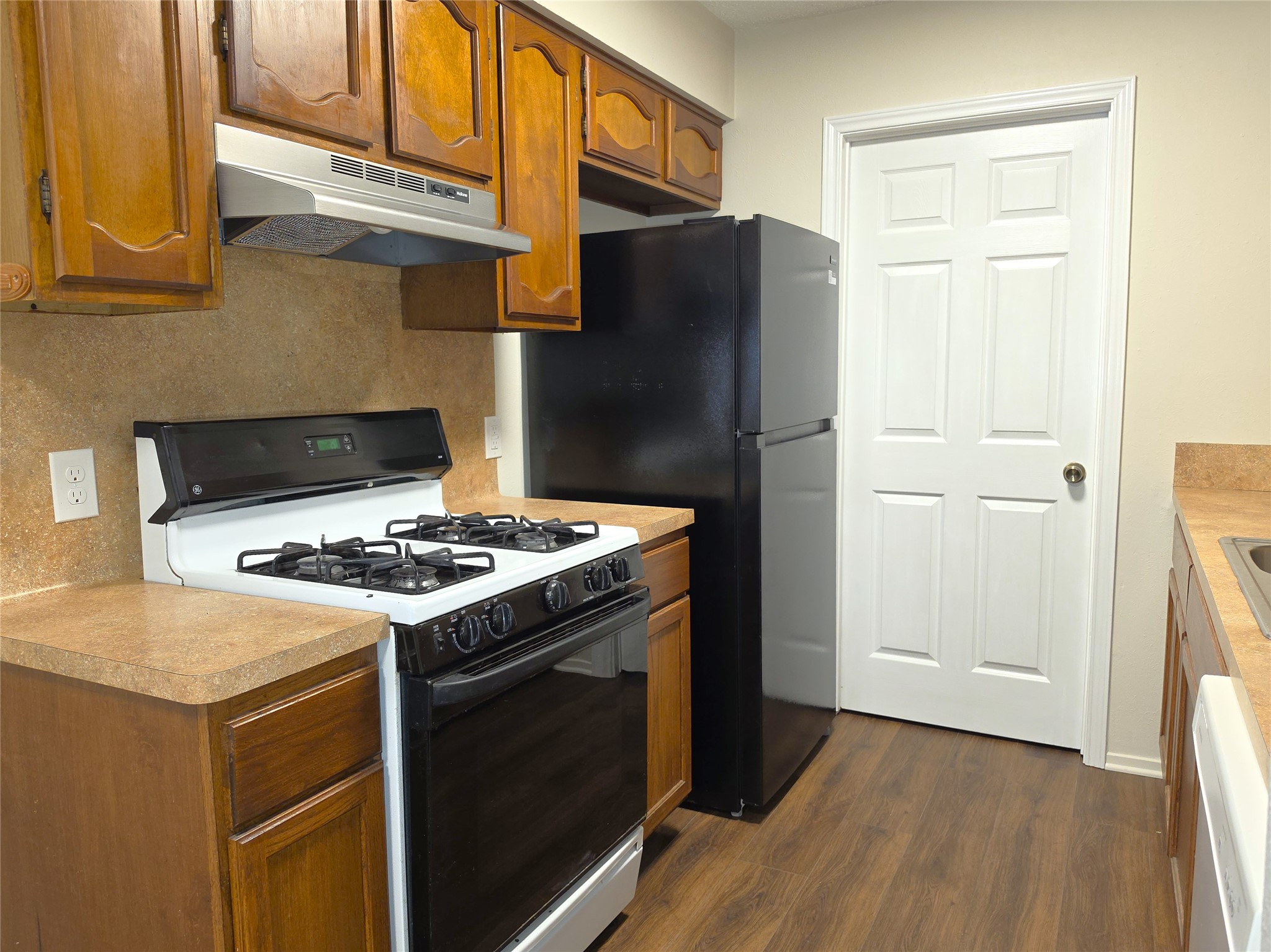 11314 Walnut Ridge Drive, Unit B Austin, TX 78753 - Photo 8 of 20 Well-maintained kitchen features classic wood cabinetry, a gas range, and a refrigerator.
