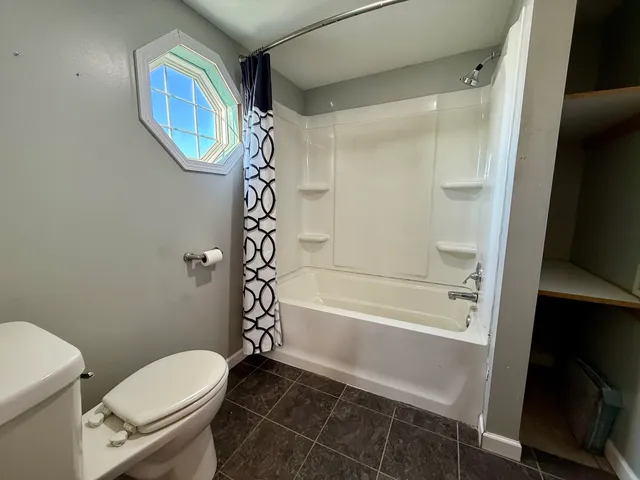 a bathroom with a toilet and a shower