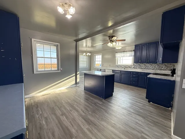 a kitchen with granite countertop wooden floors and white cabinets