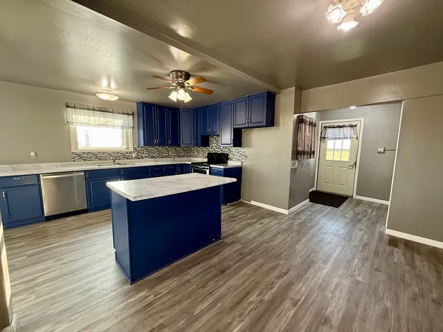 a large kitchen with wooden floors and stainless steel appliances