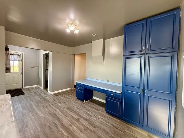 a spacious bathroom with a glass shower door and a wooden floor