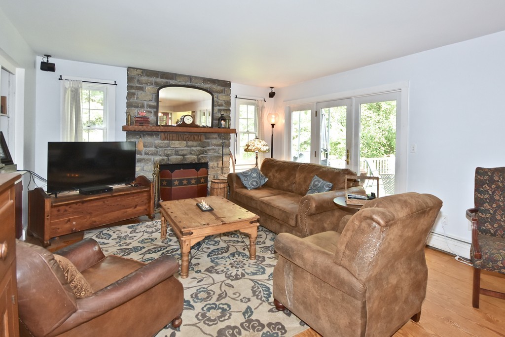 193 High Street Rochester, MA 02770 - Photo 3 of 25 a living room with furniture a fireplace and a flat screen tv