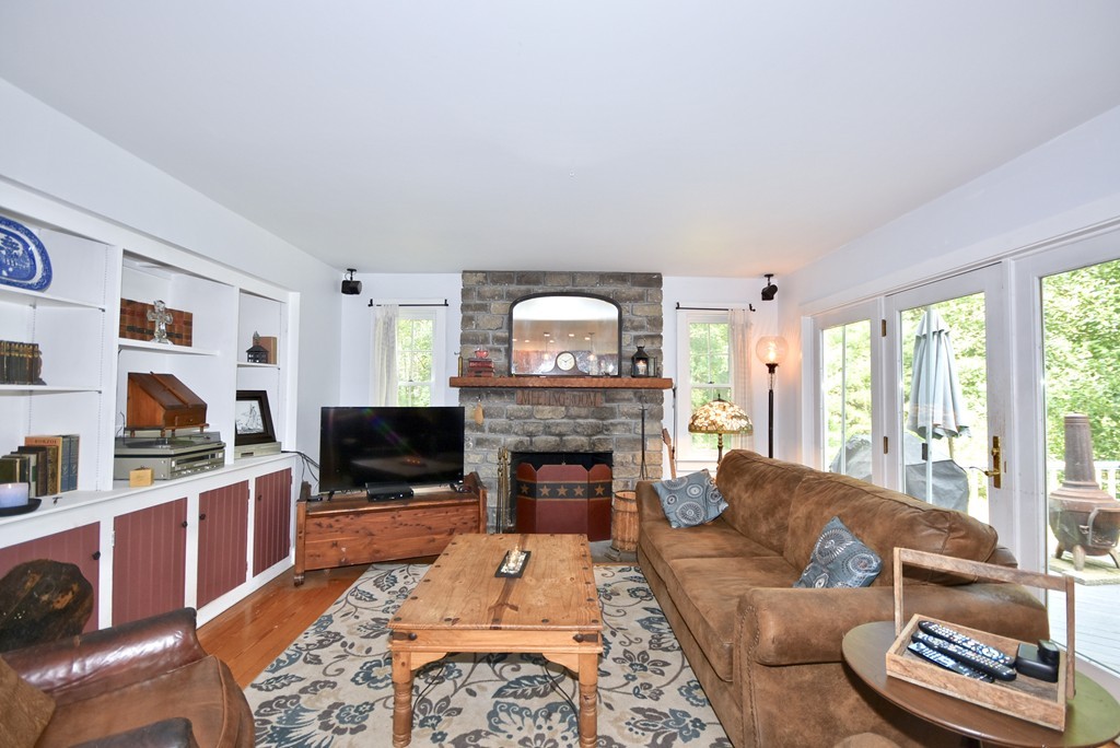 193 High Street Rochester, MA 02770 - Photo 4 of 25 a living room with furniture a fireplace and a flat screen tv