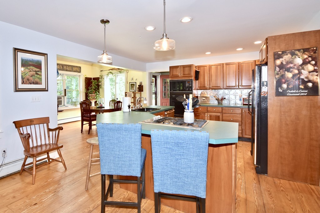 193 High Street Rochester, MA 02770 - Photo 6 of 25 a view of a dining room and livingroom with furniture wooden floor a rug a fireplace and a chandelier
