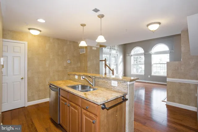 a kitchen with granite countertop a sink a counter space and stainless steel appliances
