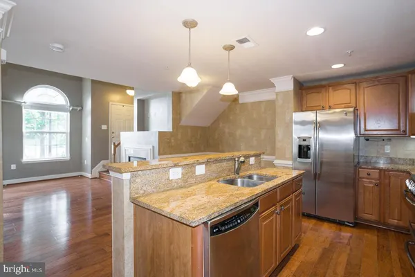 a view of kitchen with kitchen island and stainless steel appliances