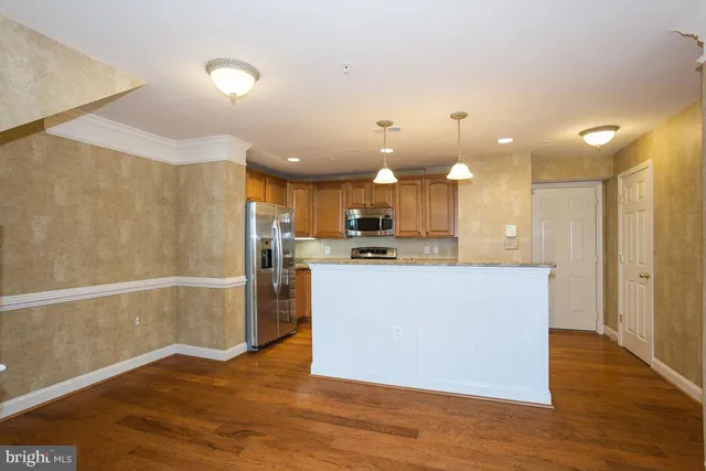 a an empty room with wooden floor and a fireplace
