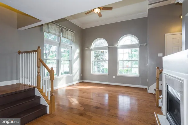 a view of a livingroom with wooden floor and a kitchen