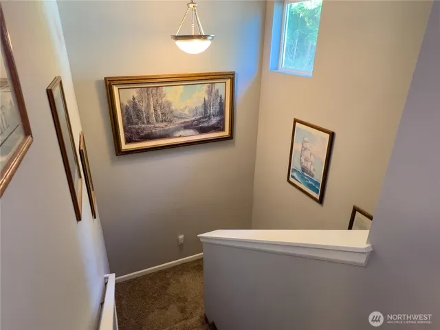 a view of a hallway with paintings on the wall