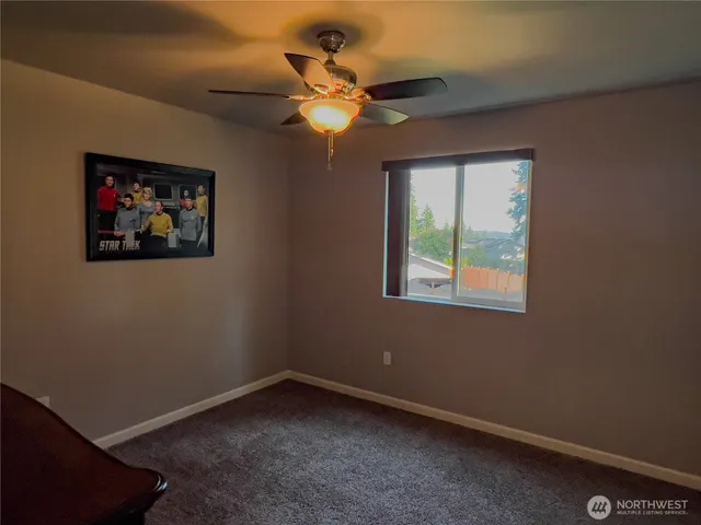 an empty room with fan and window