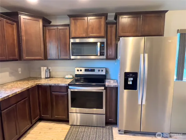 a kitchen with stainless steel appliances a refrigerator sink and microwave