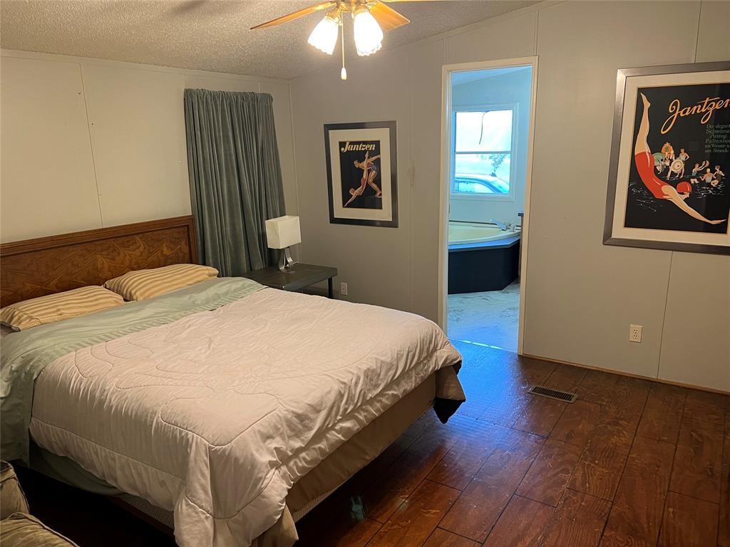 15608 Checotah Drive Austin, TX 78734 - Photo 24 of 38 a spacious bedroom with a bed and a chandelier
