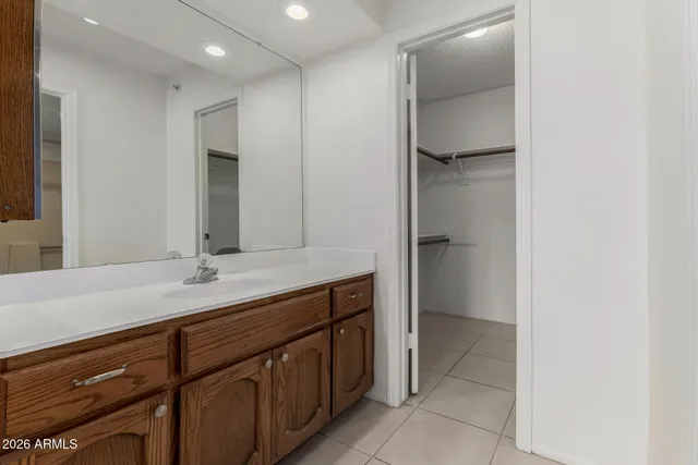 a spacious bathroom with a granite countertop sink and a mirror
