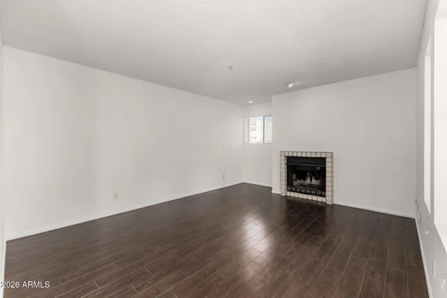 an empty room with wooden floor and fireplace