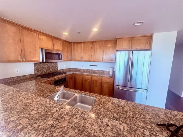 a kitchen with granite countertop a refrigerator and a sink