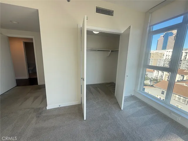 a view of an empty room with a fireplace and a window