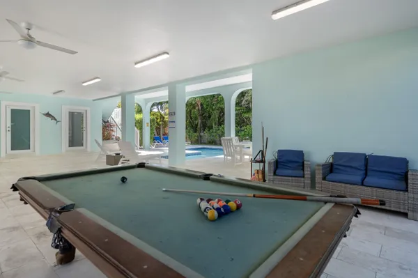 a room with furniture pool table and window