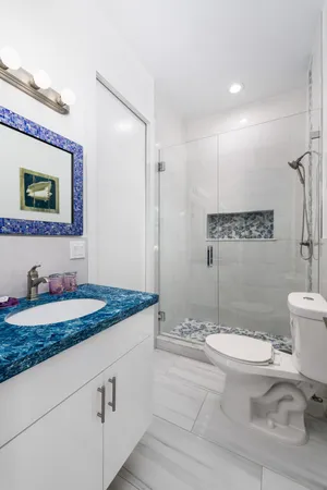 a bathroom with a granite countertop toilet sink and mirror