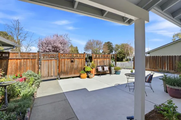 a view of a patio with couches table and chairs with potted plants