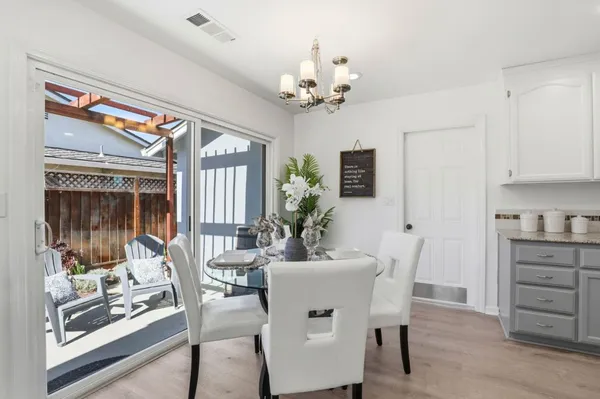 a kitchen with stainless steel appliances kitchen island granite countertop a refrigerator a stove a sink dishwasher and white cabinets with wooden floor