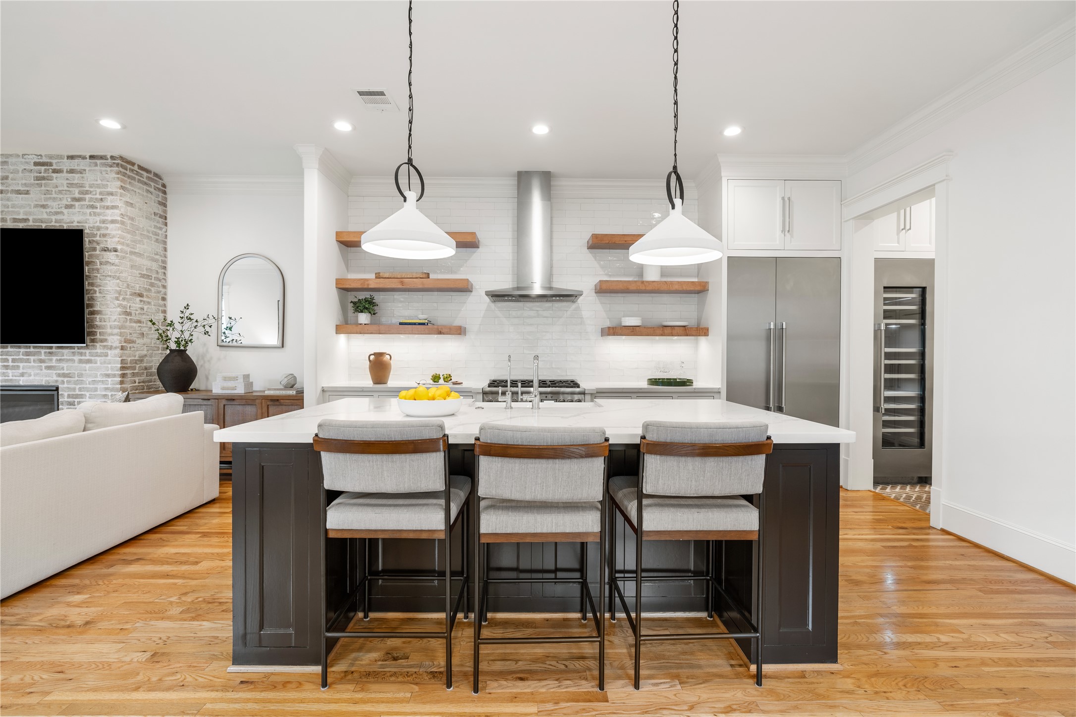 925 Tulane Street, Unit A Houston, TX 77008 - Photo 14 of 49 A wide center island breakfast bar topped with a large porcelain apron sink and Visual Comfort Limoges pendants provides generous storage and plenty of space for casual dining.