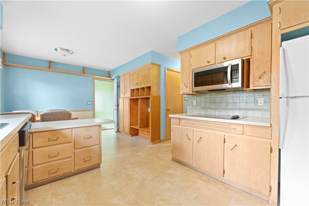 575 Overwood Road Akron, OH 44313 - Photo 11 of 45 Kitchen featuring light brown cabinets, tasteful backsplash, black electric cooktop, white refrigerator, and light tile floors