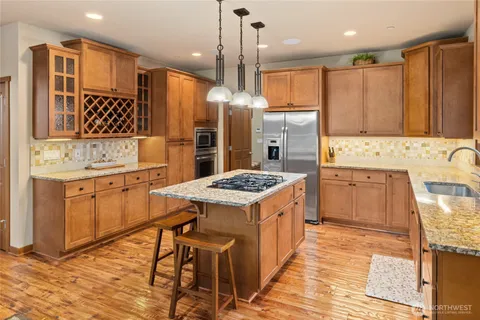 a kitchen that has a lot of cabinets in it and wooden floors