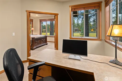 a view of a workspace with furniture and a window