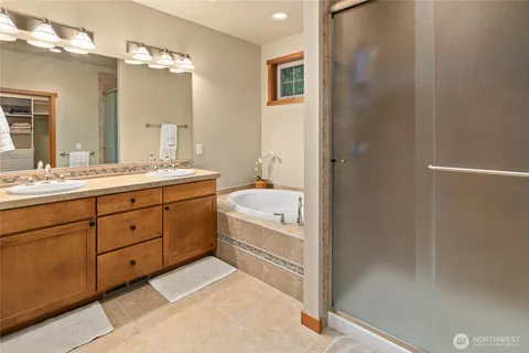 a spacious bathroom with a double vanity sink a large mirror and a shower