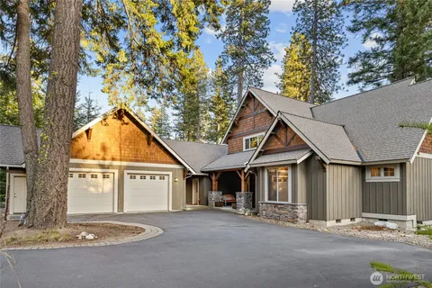 a view of a house with a tree and wooden fence