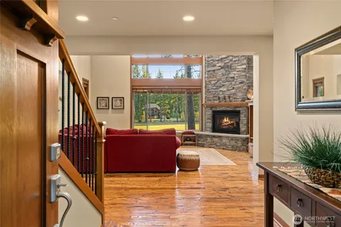 a living room with furniture large windows and a fireplace