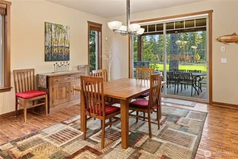 a dining room with furniture a chandelier and wooden floor