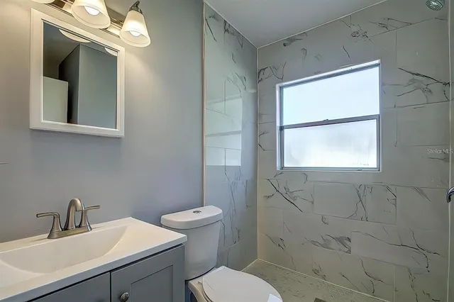 a bathroom with a sink mirror vanity and toilet