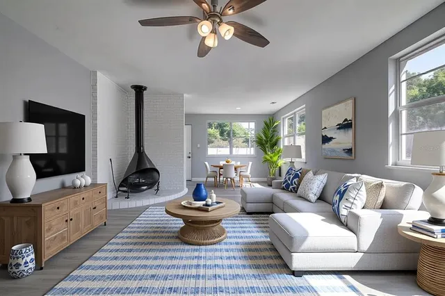 a living room with furniture a flat screen tv and a large window