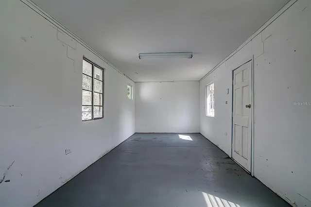 an empty room with windows and closet