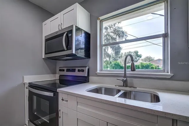 a kitchen with a stove a sink and a microwave