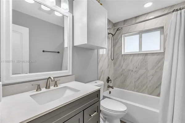 a bathroom with a sink a toilet and a large mirror