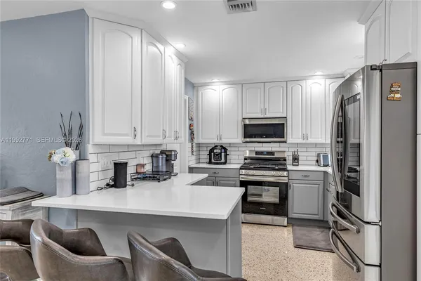 a kitchen with stainless steel appliances a stove a sink and a refrigerator