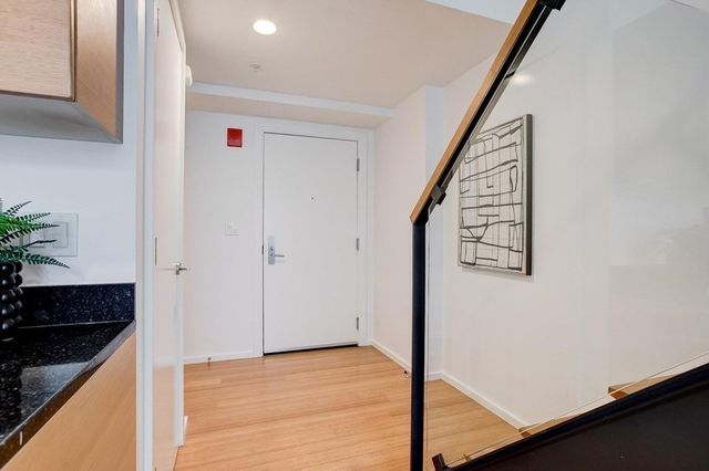 a view of an entryway with wooden floor and staircase