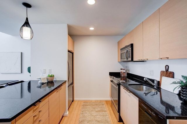 a kitchen with granite countertop a sink a stove and cabinets