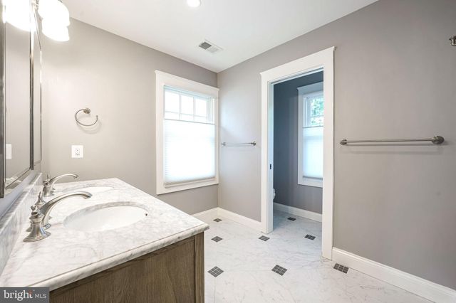 an empty room with wooden floor ceiling fan and windows