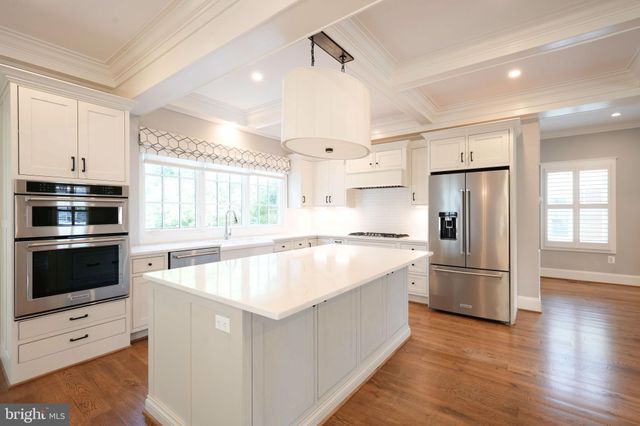 a kitchen with white cabinets and appliances