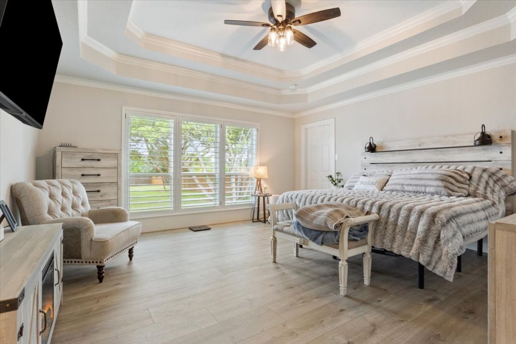190 Young Ranch Road Georgetown, TX 78633 - Photo 12 of 40 Bedroom with light wood finished floors, a ceiling fan, ornamental molding, and a tray ceiling