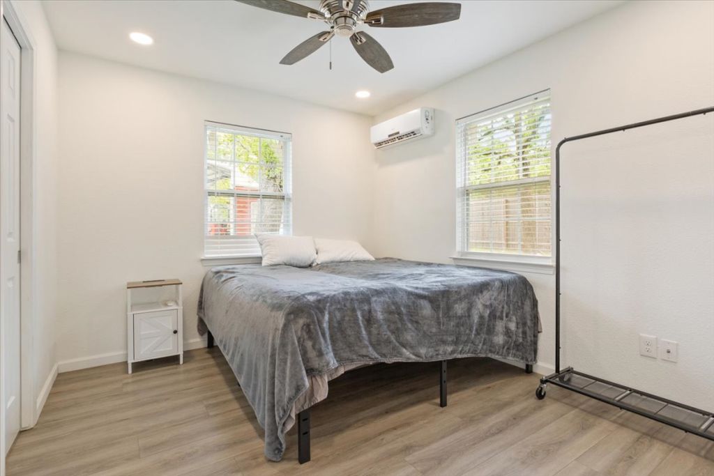 190 Young Ranch Road Georgetown, TX 78633 - Photo 22 of 40 Bedroom featuring light wood finished floors, multiple windows, a ceiling fan, and recessed lighting