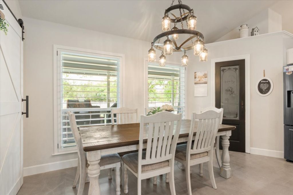 190 Young Ranch Road Georgetown, TX 78633 - Photo 31 of 40 Dining space with suspended lighting, a barn door, and vaulted ceiling