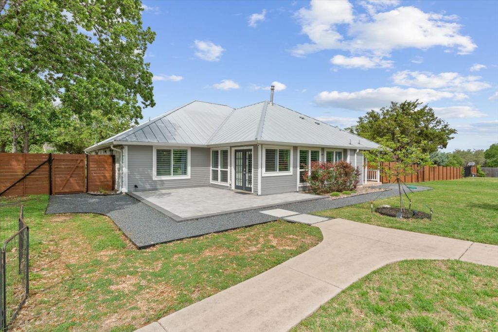 190 Young Ranch Road Georgetown, TX 78633 - Photo 37 of 40 Rear view of house featuring a fenced backyard, a gate, a patio, and a metal roof