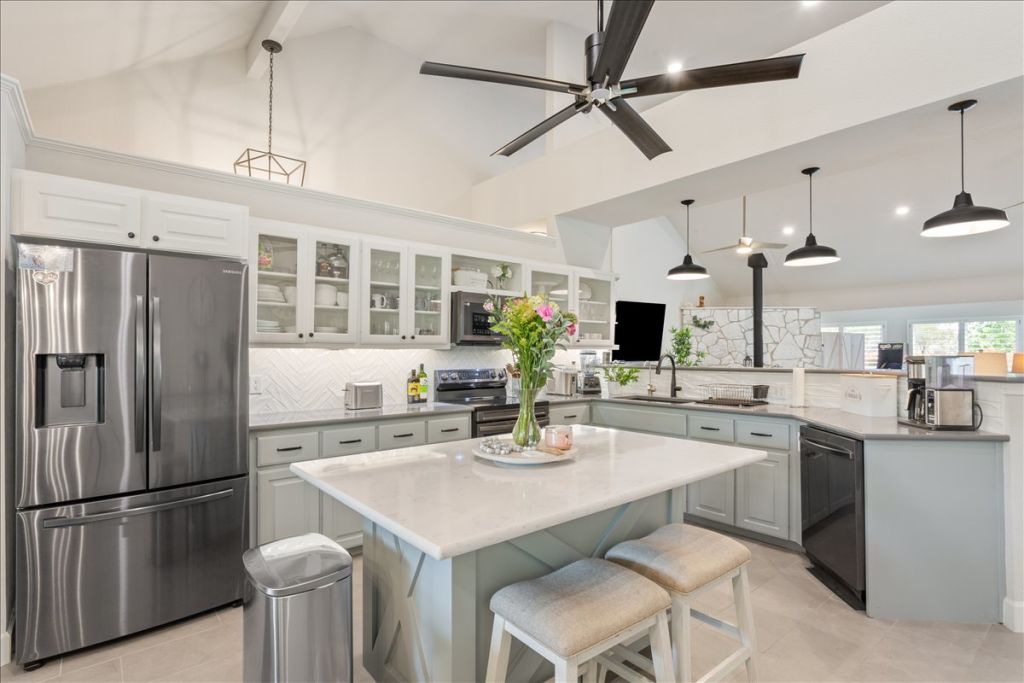 190 Young Ranch Road Georgetown, TX 78633 - Photo 5 of 40 Kitchen featuring hanging light fixtures, stainless steel appliances, decorative backsplash, lofted ceiling, and a kitchen breakfast bar