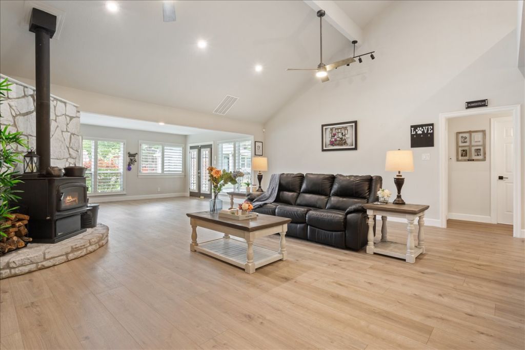 190 Young Ranch Road Georgetown, TX 78633 - Photo 8 of 40 Living area with a wood stove, light wood-style floors, a ceiling fan, vaulted ceiling, and recessed lighting